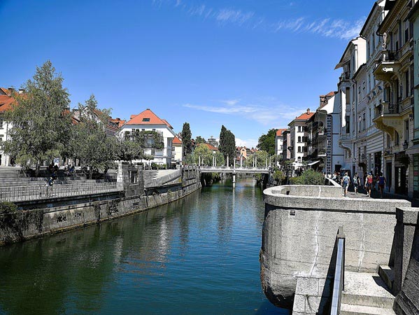 Een foto van de rivier Ljubljanica met in de verte de schoenmakersbrug