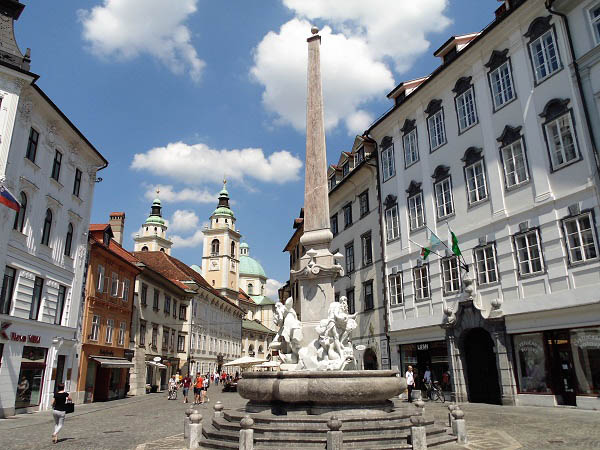 Een zicht op de rechts gelegen Fontein van de 3 rivieren gelegen in de omgeving van het Prešerenplein in het historische centrum van Ljublajna 