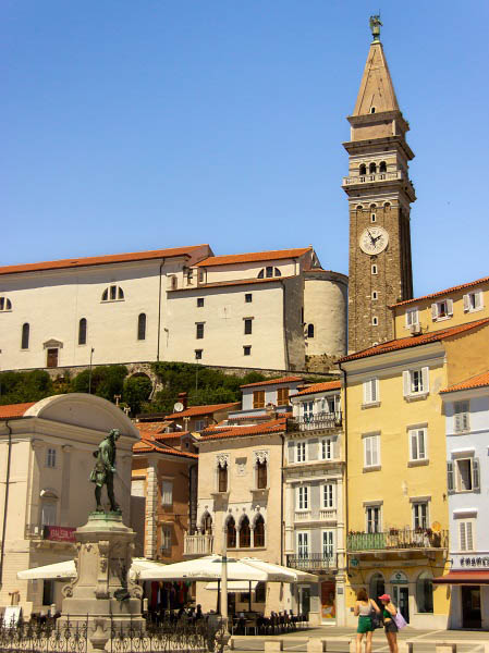 Links het standbeeld van violist Tartini, in het midden de witte gevel van het Venetiaans palazzo, rechts de klokkentoren van de Georgiuskathedraal
