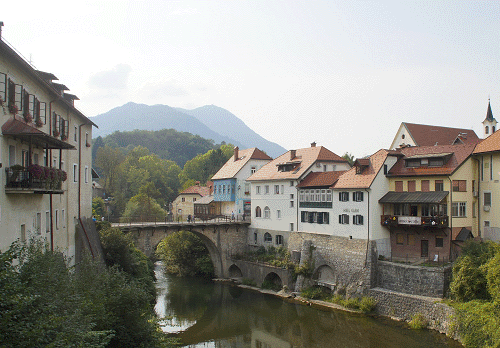 Een kijk op de Kapucijnenbrug, de Selška Sora rivier en rechts de Kapucijnenkerk in Škofja Loka