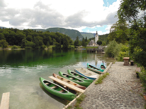 Een blik op het sprookjesachtige Meer van Bohinj, met in de achtergrond de Julische Alpen en de Johannes Kerk