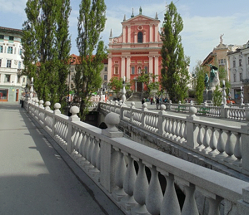 Een blik op het Prešerenplein met links de Barokke Franciscuskerk en rechts het standbeeld van France Prešeren